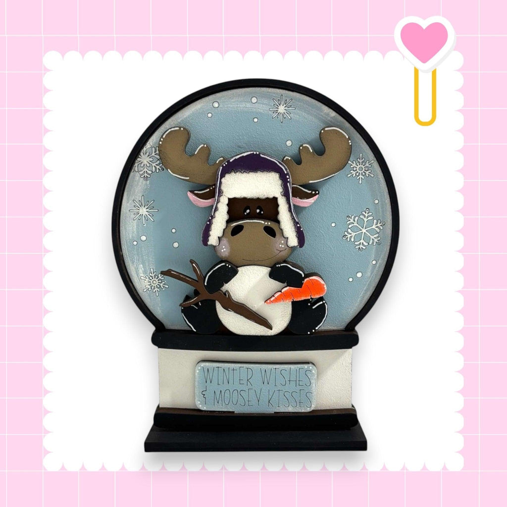 a snow globe with a moose wearing a hat