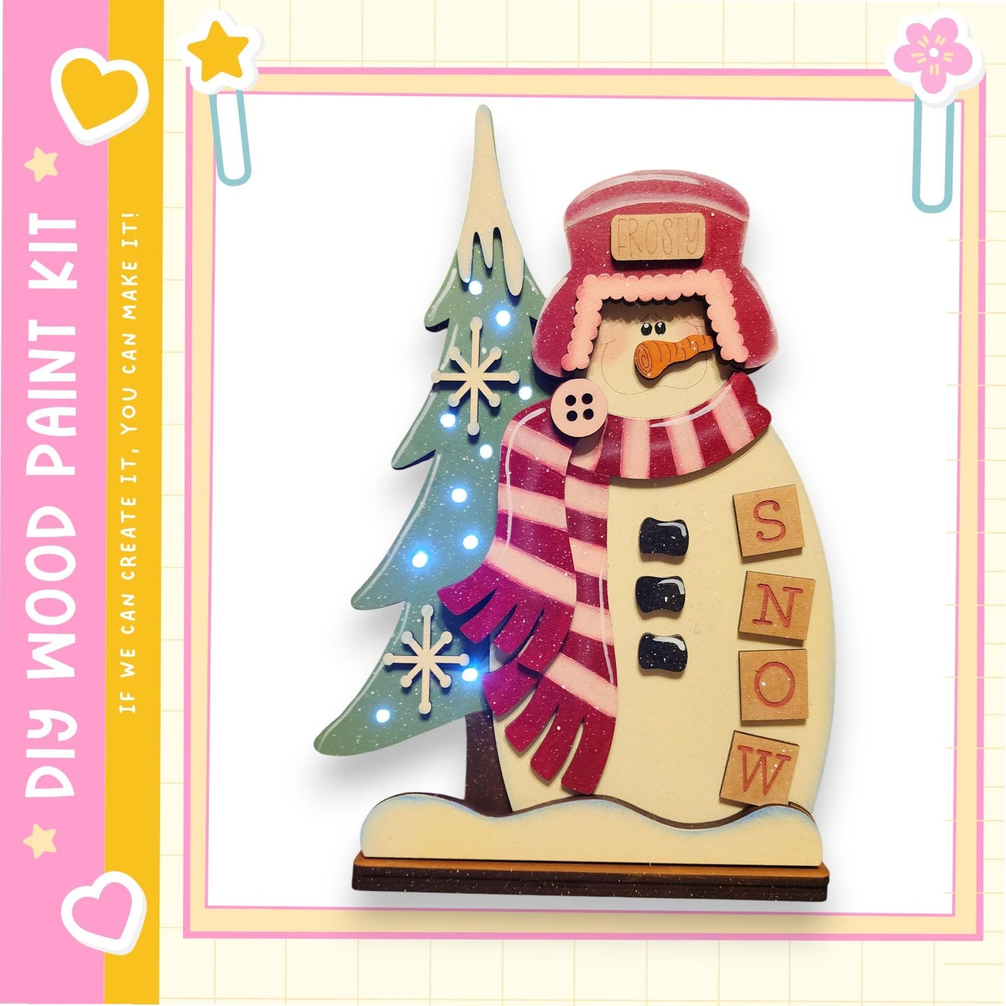 A wooden snowman decoration with a tree and snowflakes, featuring the word "SNOW" on its body.