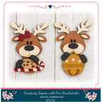 two wooden reindeer or antlers, each holding a different ornament, against a white wooden background.
