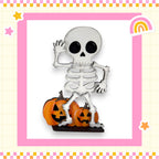 A skeleton figurine is standing on top of two carved pumpkins, with a rainbow and stars surrounding the scene.