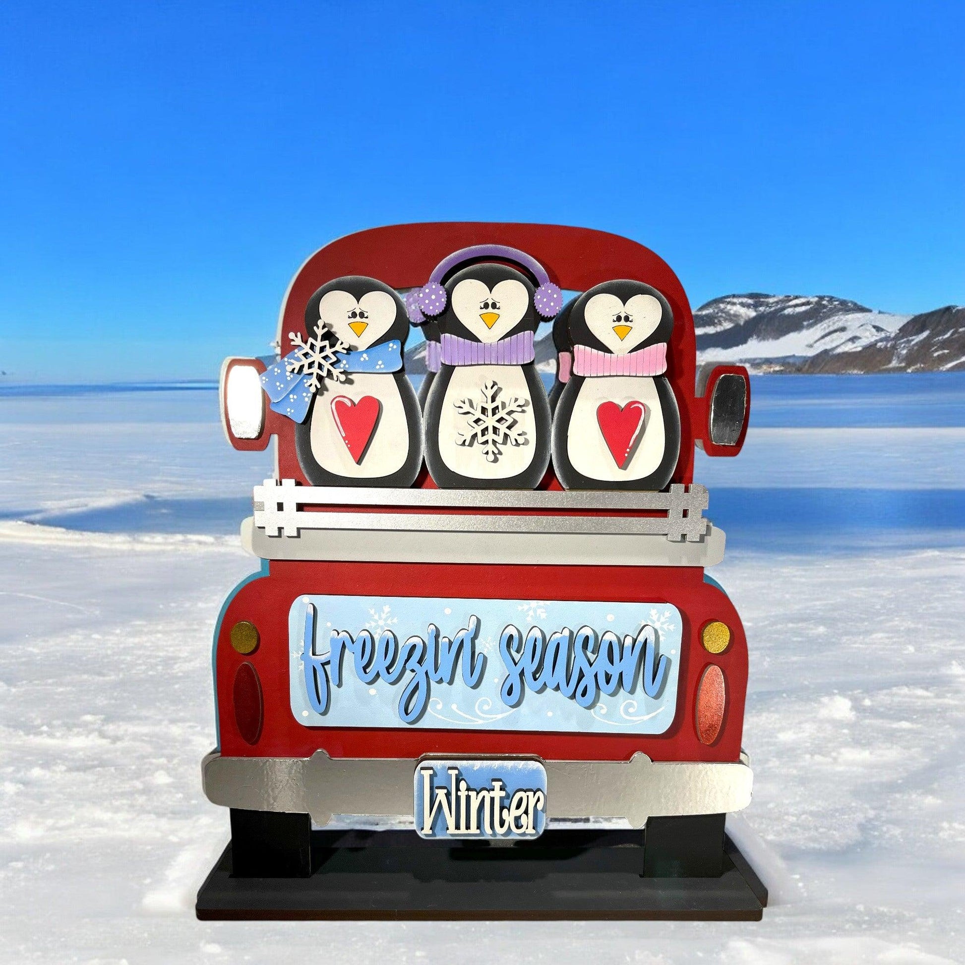 a red truck with penguins on the back of it