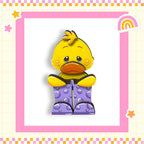 A yellow duck wearing purple polka dot boots is sitting in a pink and yellow checkered frame.