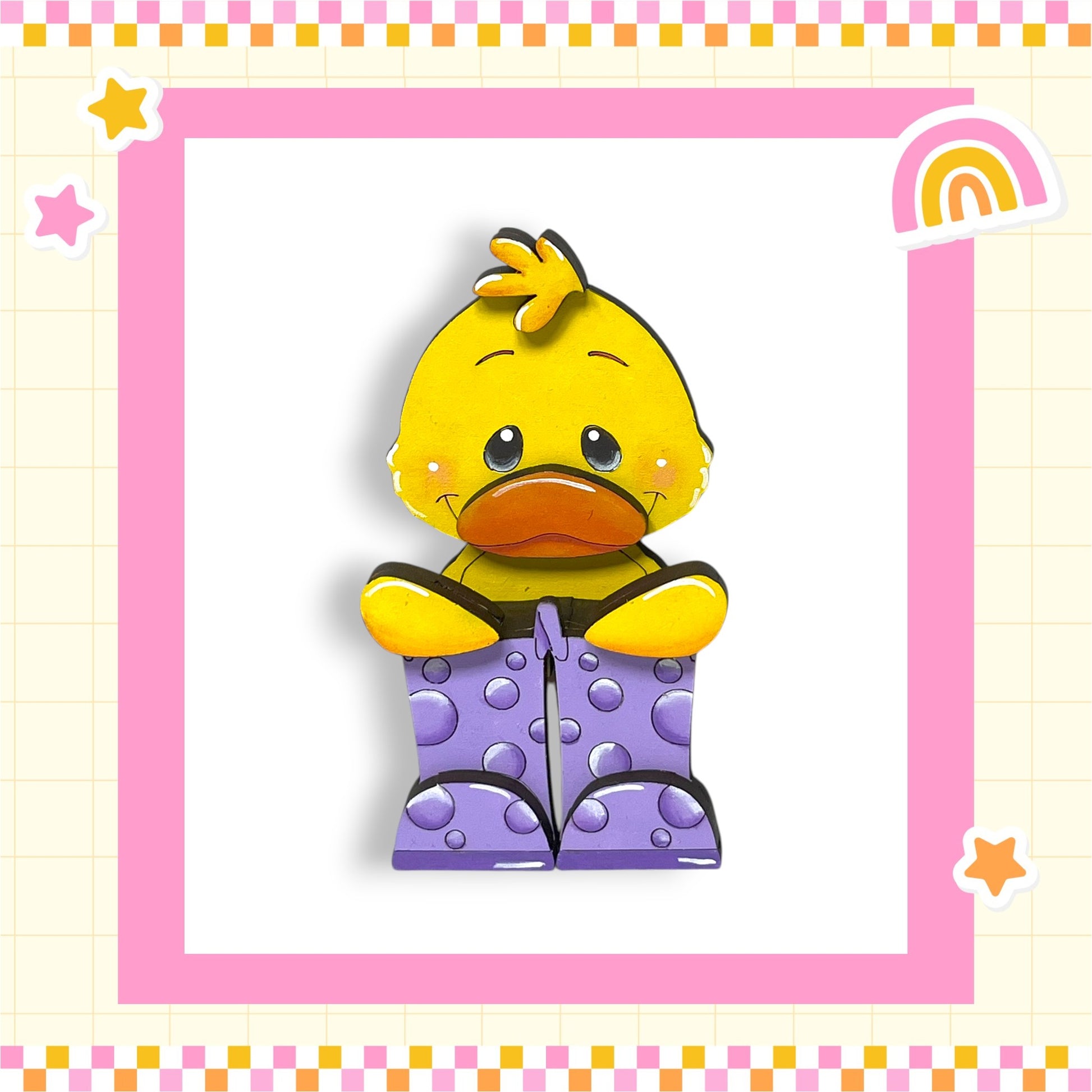 A yellow duck wearing purple polka dot boots is sitting in a pink and yellow checkered frame.