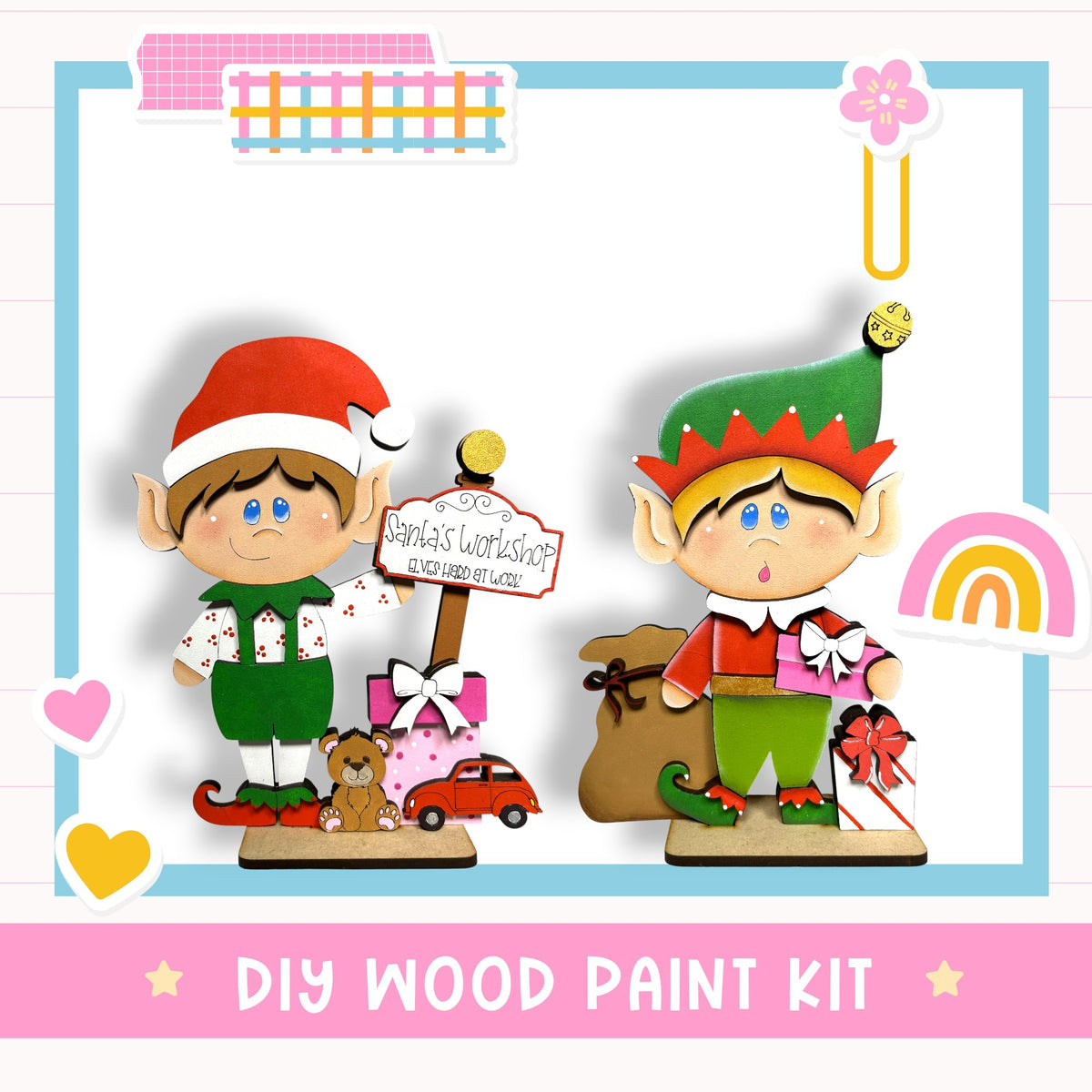 two wooden elf figurines, one wearing a green outfit and the other wearing a red outfit, standing next to each other and holding presents. The background includes a sign that says "Santa's Workshop" and a rainbow. The image also includes a text that says "DIY WOOD PAINT KIT" at the bottom.