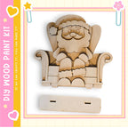 A wooden Christmas-themed decoration kit, featuring a wooden Santa Claus figure sitting in a chair.