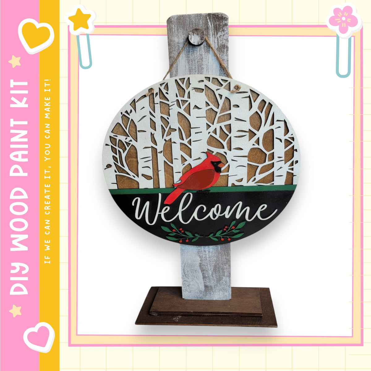 a wooden sign with a red cardinal bird perched on it, surrounded by a snowy forest scene. The sign is hanging on a wooden post, and the word "Welcome" is written on it.