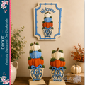 a creative DIY kit for decorating with pumpkins, including a welcome sign and decorative planters. The kit includes pumpkins in various colors, such as orange, white, and blue, as well as decorative elements like ribbons and flowers. The pumpkins are stacked in different sizes and placed in vases, creating a visually appealing display. The kit is set against a backdrop of a wall with a framed picture of pumpkins, adding to the festive atmosphere.