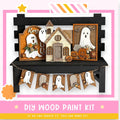The image is a Halloween-themed DIY wood paint kit, featuring various wooden decorations such as ghost houses, pumpkins, and banners.