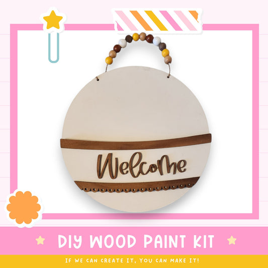 a DIY wood paint kit with a welcome sign hanging on a wall.