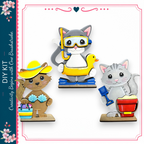 three cute cat figurines, each wearing different accessories and engaging in various activities, such as swimming with a duck, playing in the sand, and holding a bucket.