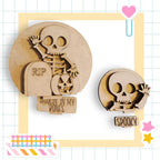 two wooden cutouts of skulls, one larger and one smaller, with text and decorations surrounding them.