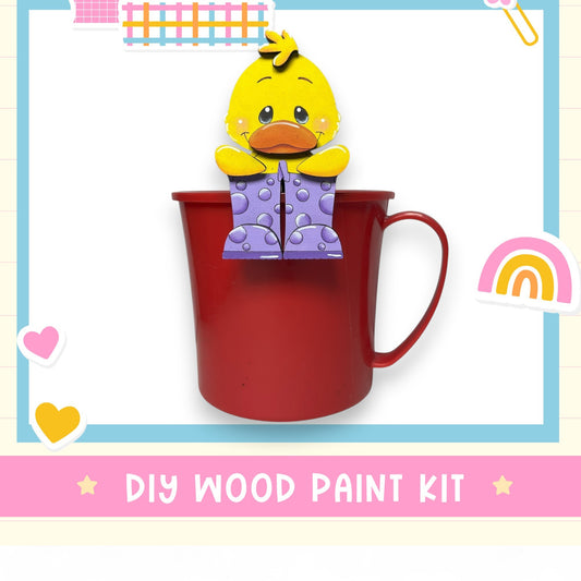 A red mug with a yellow duck figurine sitting inside it, surrounded by various colorful stickers and hearts.