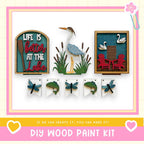 The image is a collage of various wooden paint kit items, including a sign that says "Life is better at the lake", a bird, a chair, a dragonfly, and a fish. The text "If we can create it, you can make it!" is displayed, suggesting that the kit is designed for DIY wood paint projects.