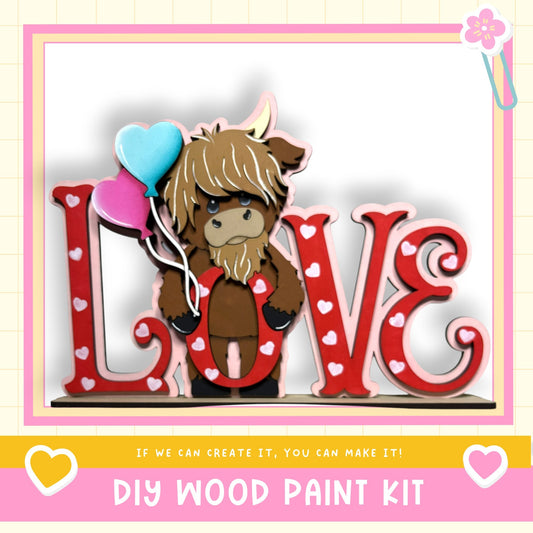 A wooden sign with the word "LOVE" written on it, featuring a cartoon character holding balloons. The sign is surrounded by heart-shaped decorations.