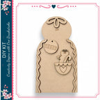 a wooden gingerbread house kit with a cheerful gingerbread man and a heart-shaped tag.