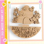 a wooden craft kit with a beehive design and flowers, along with a sign that says "Busy bees make sweet days".