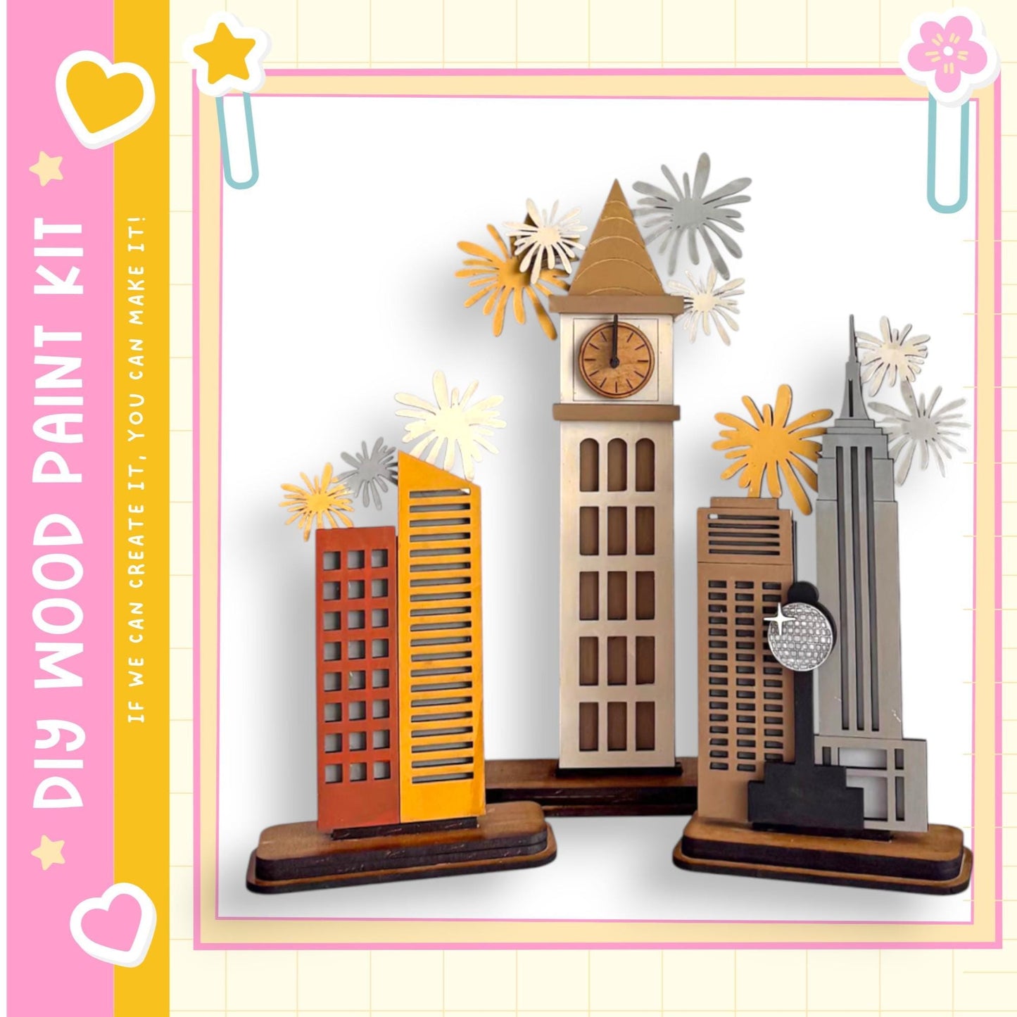 A wooden paint kit featuring a miniature cityscape with various buildings, including a clock tower, surrounded by decorative paper flowers.