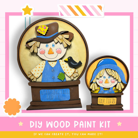 a DIY wood paint kit for creating a scarecrow-themed decoration, with two scarecrow figures made from wood and painted with colorful details.
