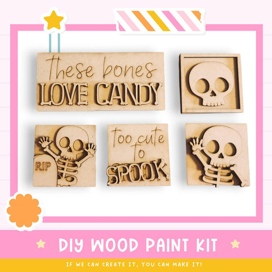 The image is a DIY wood paint kit featuring various wooden cutouts in the shape of bones, including a skeleton, a skull, and a bone. The kit appears to be designed for creating custom wooden decorations or art pieces.