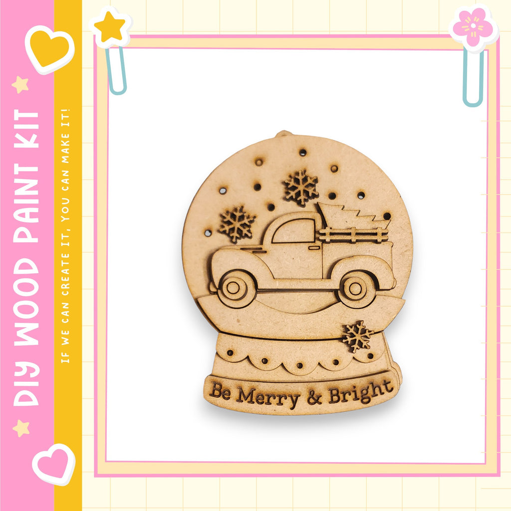 A wooden snow globe with a truck on top, surrounded by snowflakes, is displayed against a pink and yellow background.