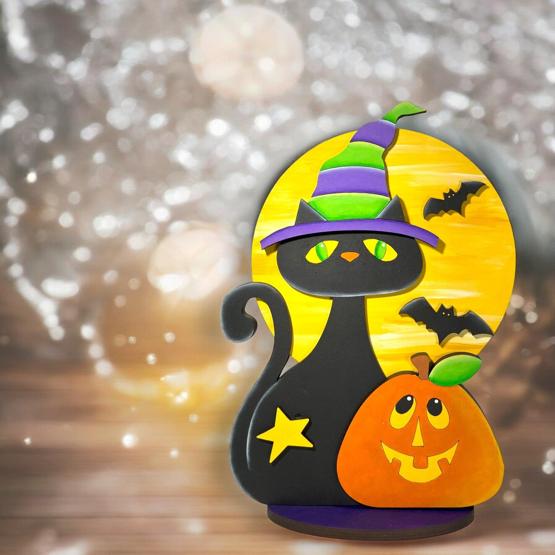 a black cat wearing a witches hat with a pumpkin