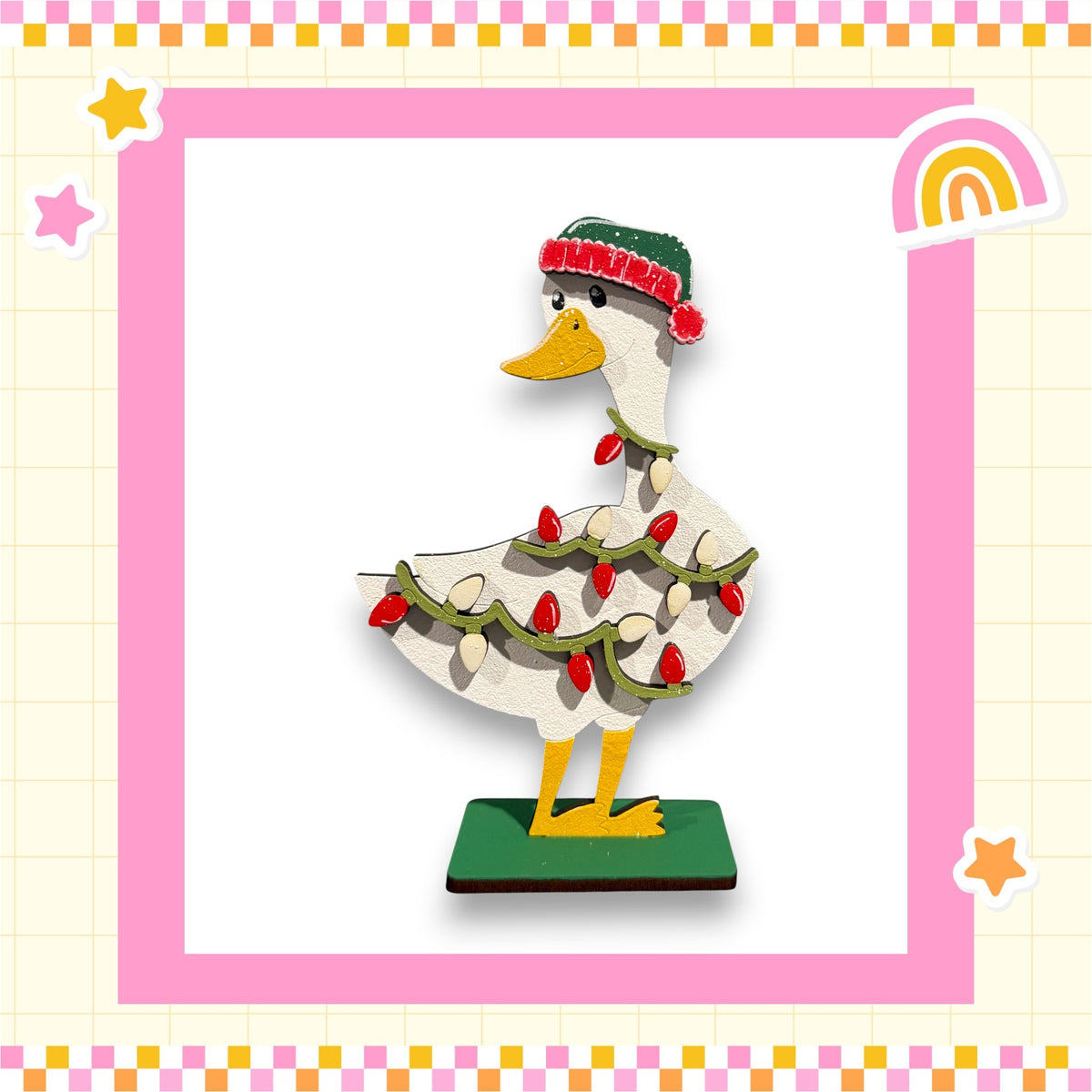 A wooden duck statue decorated with Christmas lights and a hat, standing on a green base.