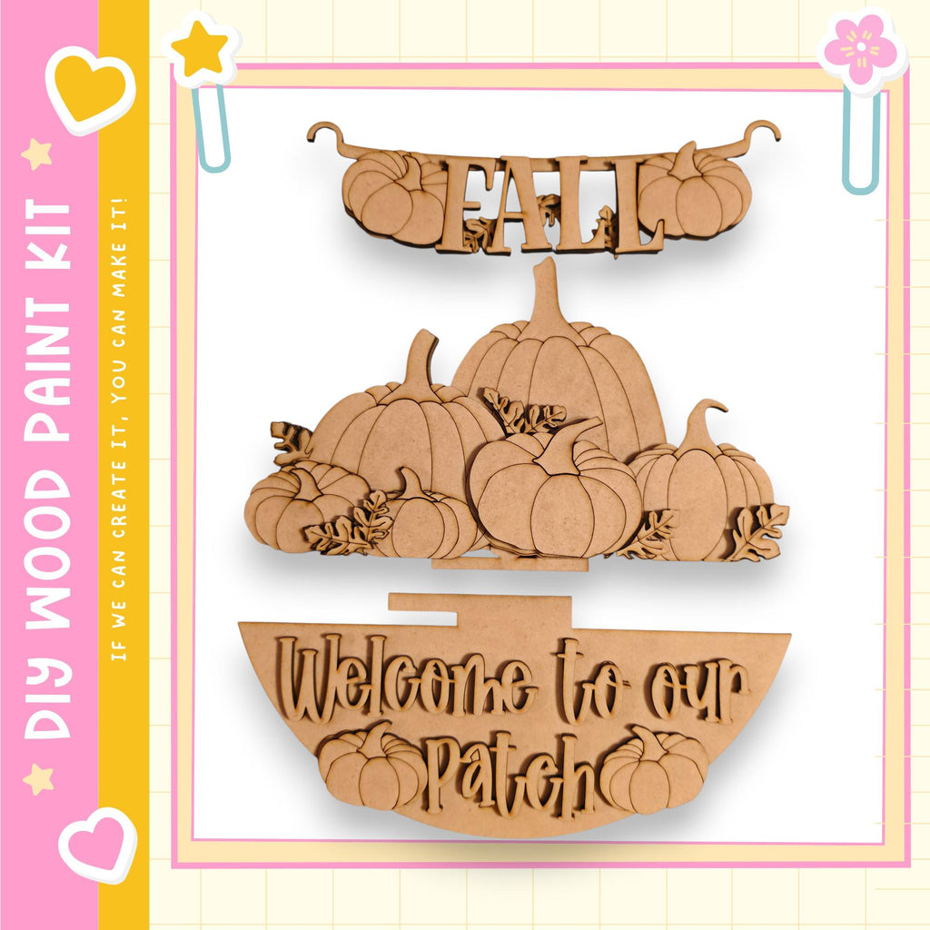 a wooden sign with the word "Fall" written on it, along with a wooden bowl and several wooden pumpkins. The sign is hanging on a wall, and the wooden bowl is placed on the ground. The pumpkins are arranged in a decorative manner, creating a welcoming atmosphere for visitors to the patch.