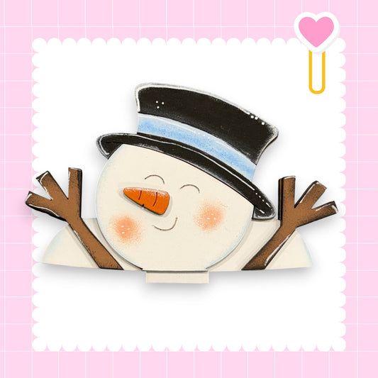 A cheerful snowman with a black top hat and brown sticks, smiling and waving with its arms raised against a pink background with a scalloped edge.