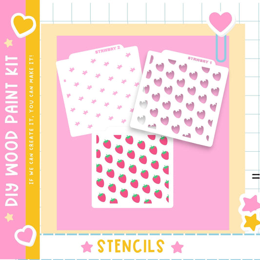 The image is a colorful and playful advertisement for a DIY wood paint kit, featuring three stencil designs with hearts and strawberries on a pink background.