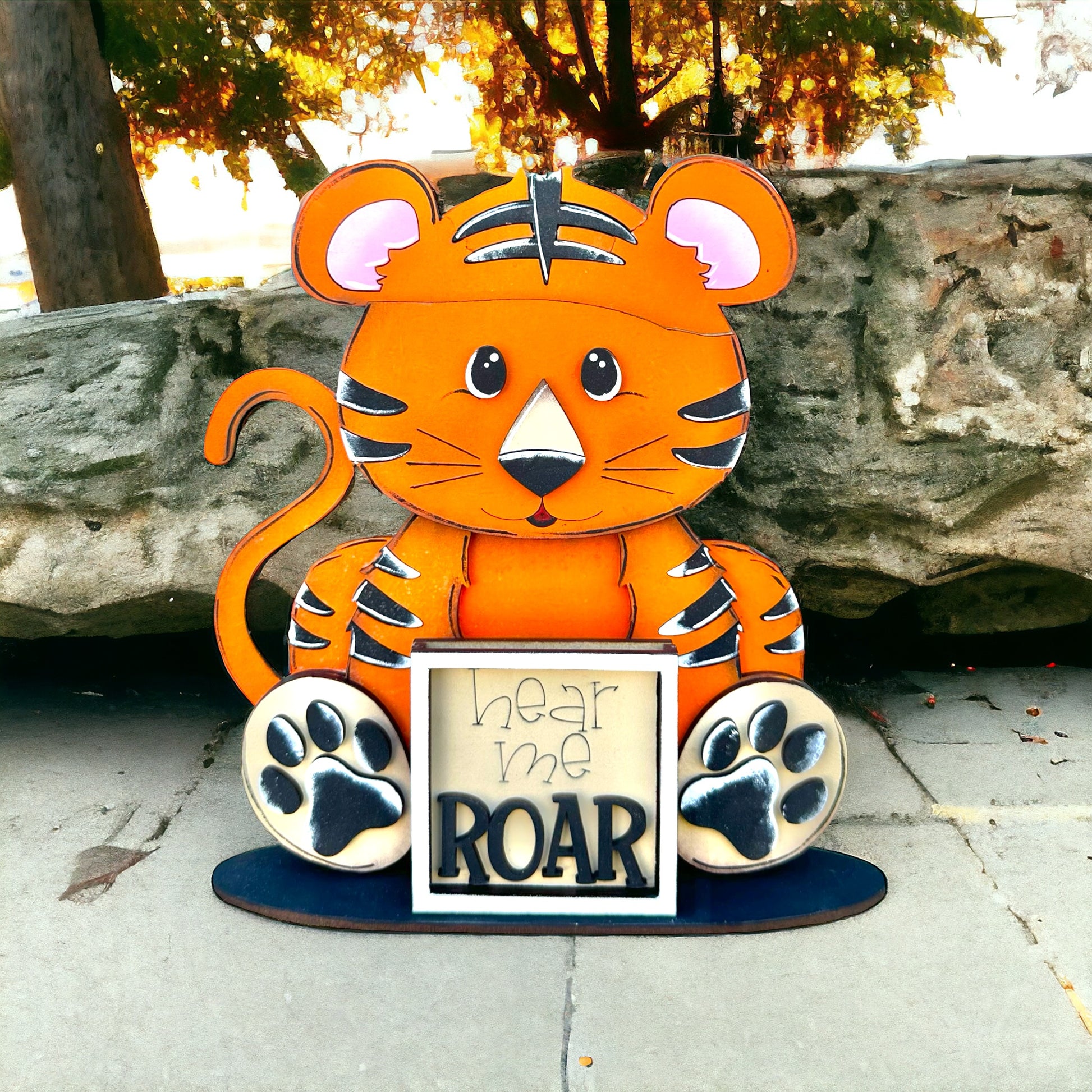 a paper cut out of a tiger holding a sign