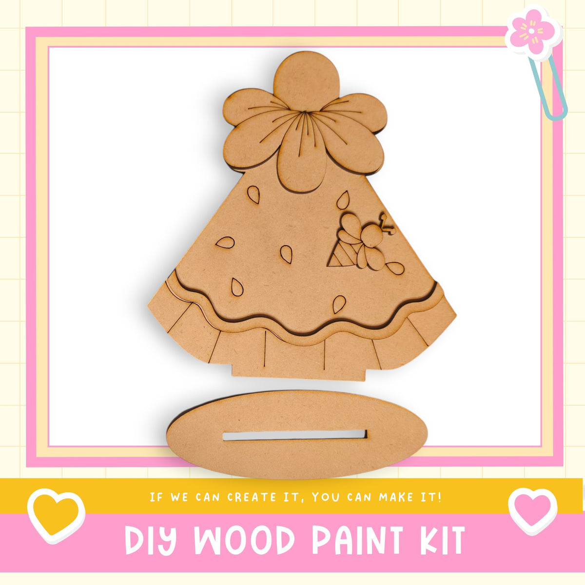 a DIY wood paint kit, including a wooden dress and a wooden stand, with a pink and white border.