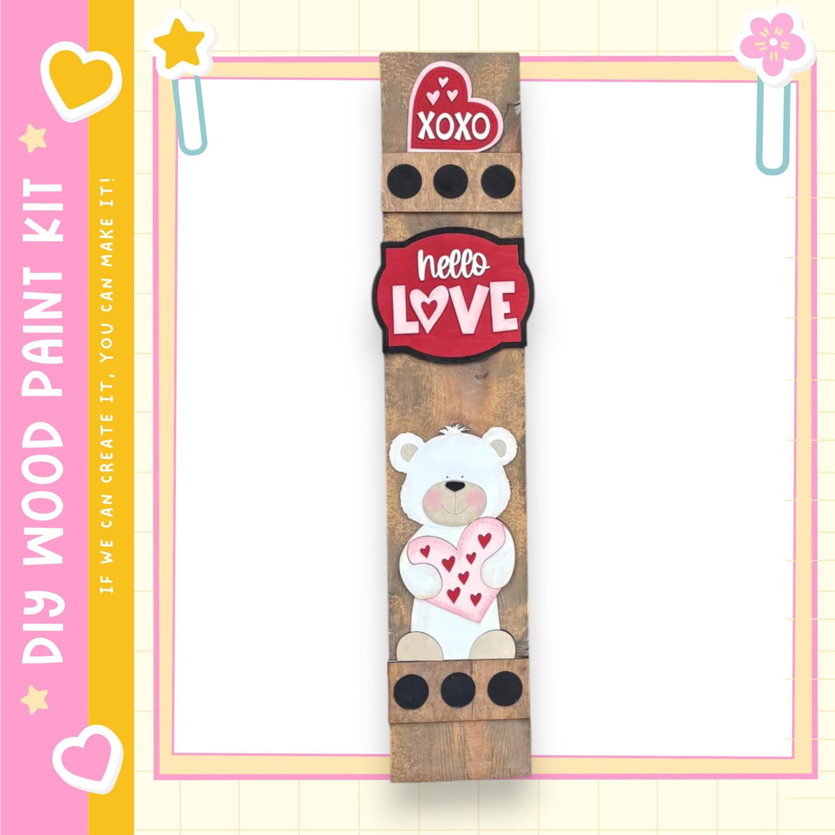 a wooden sign with a teddy bear and heart-shaped decorations, including a "XOXO" sign. The sign is surrounded by a pink and yellow border, and there is a heart-shaped sticker on the top left corner.