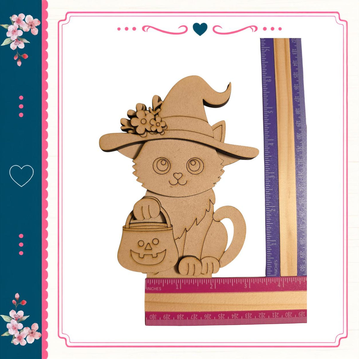 A wooden cutout of a cat wearing a witch's hat and holding a carved pumpkin, with a ruler placed next to it.