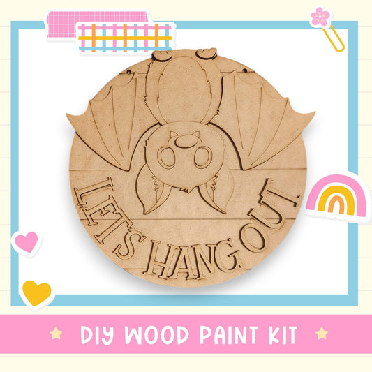 A DIY wood paint kit featuring a wooden bat with the text "LET'S HANG OUT" carved into it.