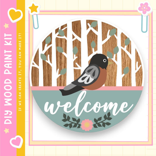 A welcome sign featuring a bird sitting on a wooden branch with leaves, surrounded by a pink and green border.