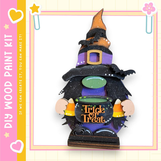 A whimsical wooden gnome figure dressed as a witch, holding a cauldron and a "Trick or Treat" sign, set against a pink and yellow background with decorative elements.