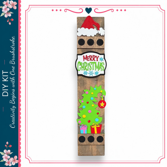 a wooden sign with a festive Christmas theme, including a Santa hat, a tree, and various holiday decorations.