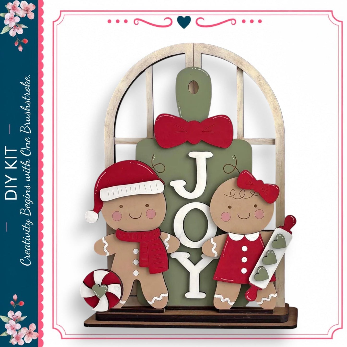 A DIY kit featuring a gingerbread man and a girl, with the word "JOY" displayed on a green sign.