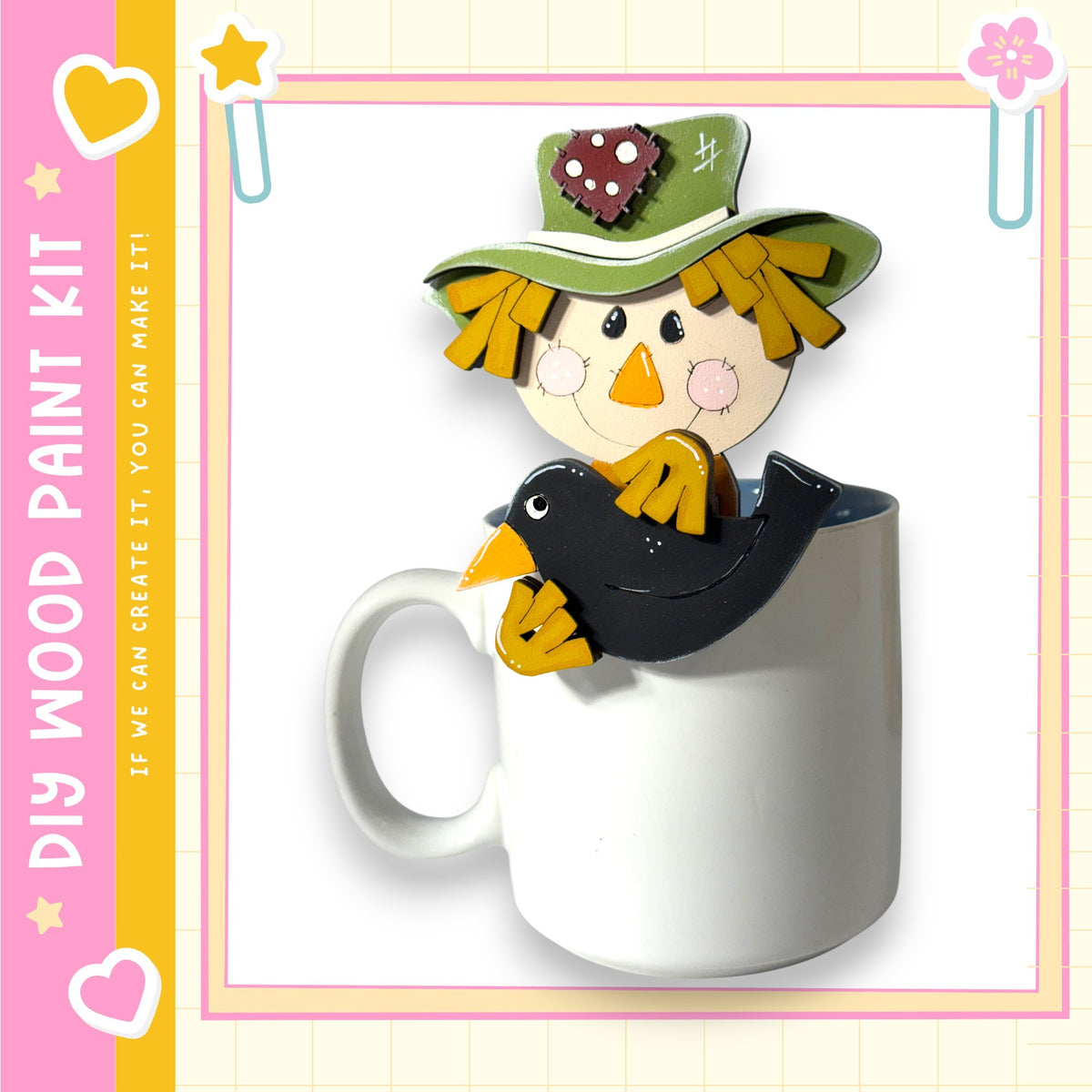A wooden paint kit featuring a scarecrow figure sitting inside a white mug, with a heart and star design on the mug.