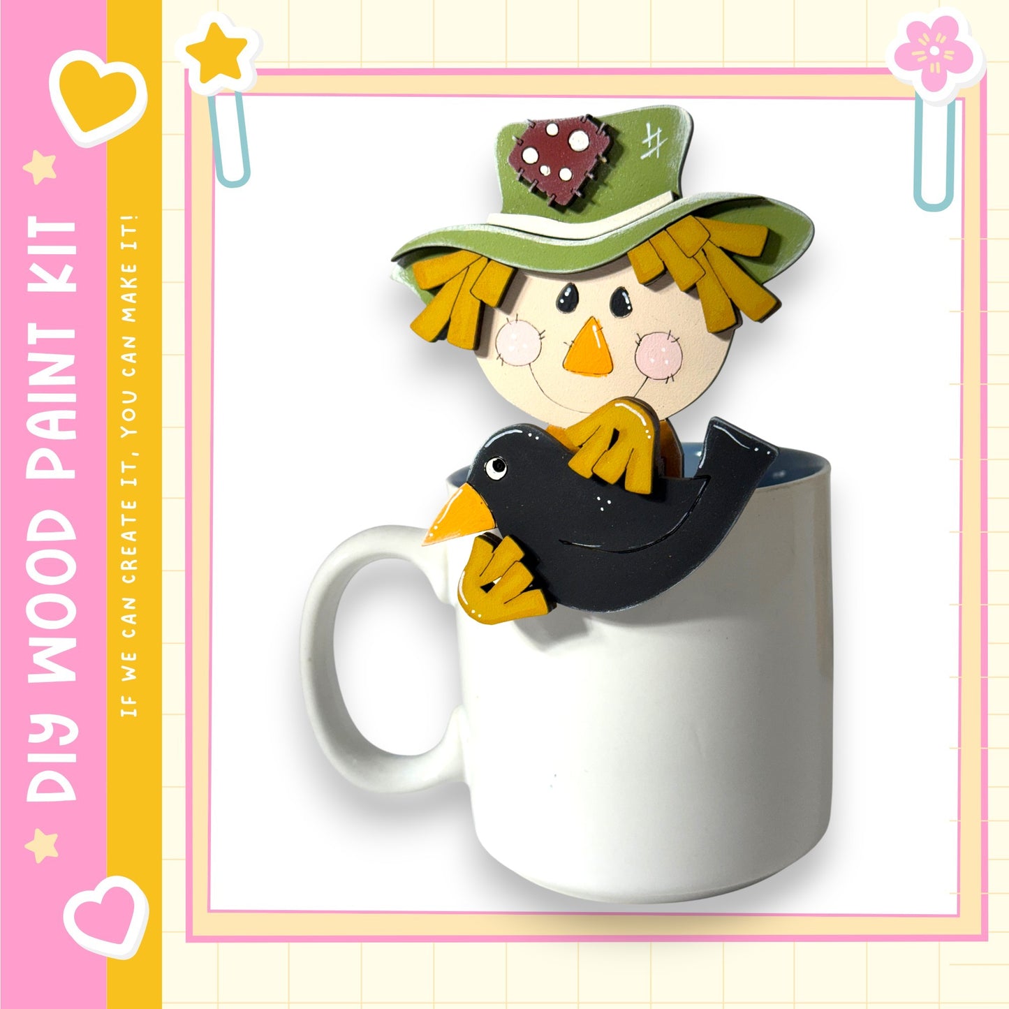 A wooden paint kit featuring a scarecrow figure sitting inside a white mug, with a heart and star design on the mug.