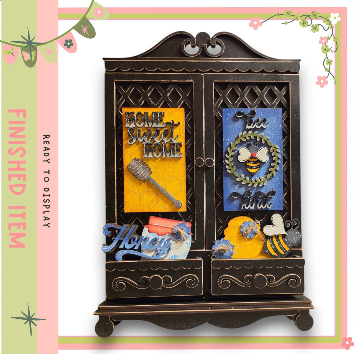 The image is a decorative wooden cabinet with various items on its surface, including a honeycomb, a bee, and other floral and honey-related elements.