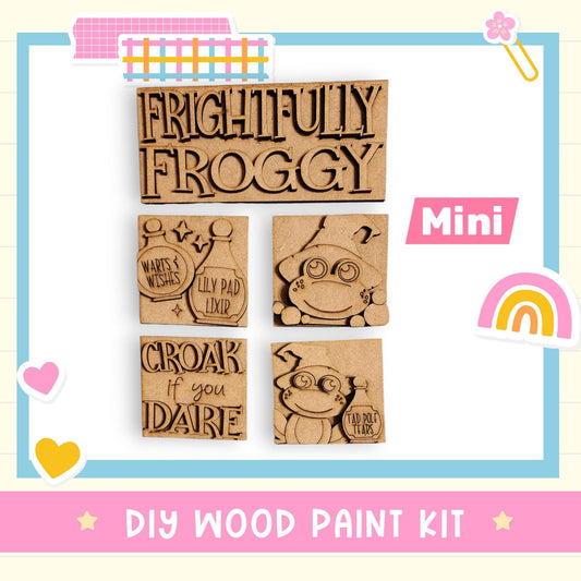 The image is a DIY wood paint kit featuring a variety of cute and whimsical frog-themed designs.