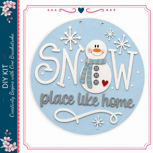 A snowman decoration with the text "SNOW place like home" and snowflakes surrounding it.