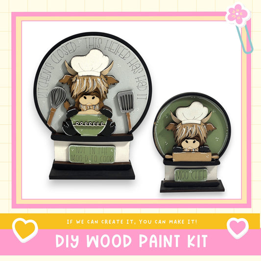 two wooden paint kits, each depicting a cartoon cow character wearing a chef's hat. The kits are labeled as "DIY WOOD PAINT KIT" and "MOO CHEF".
