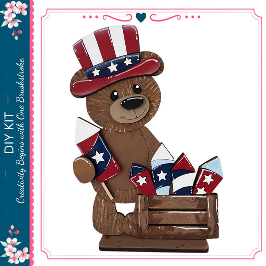 A wooden teddy bear wearing a patriotic hat and holding a flag, with fireworks in a wooden crate.