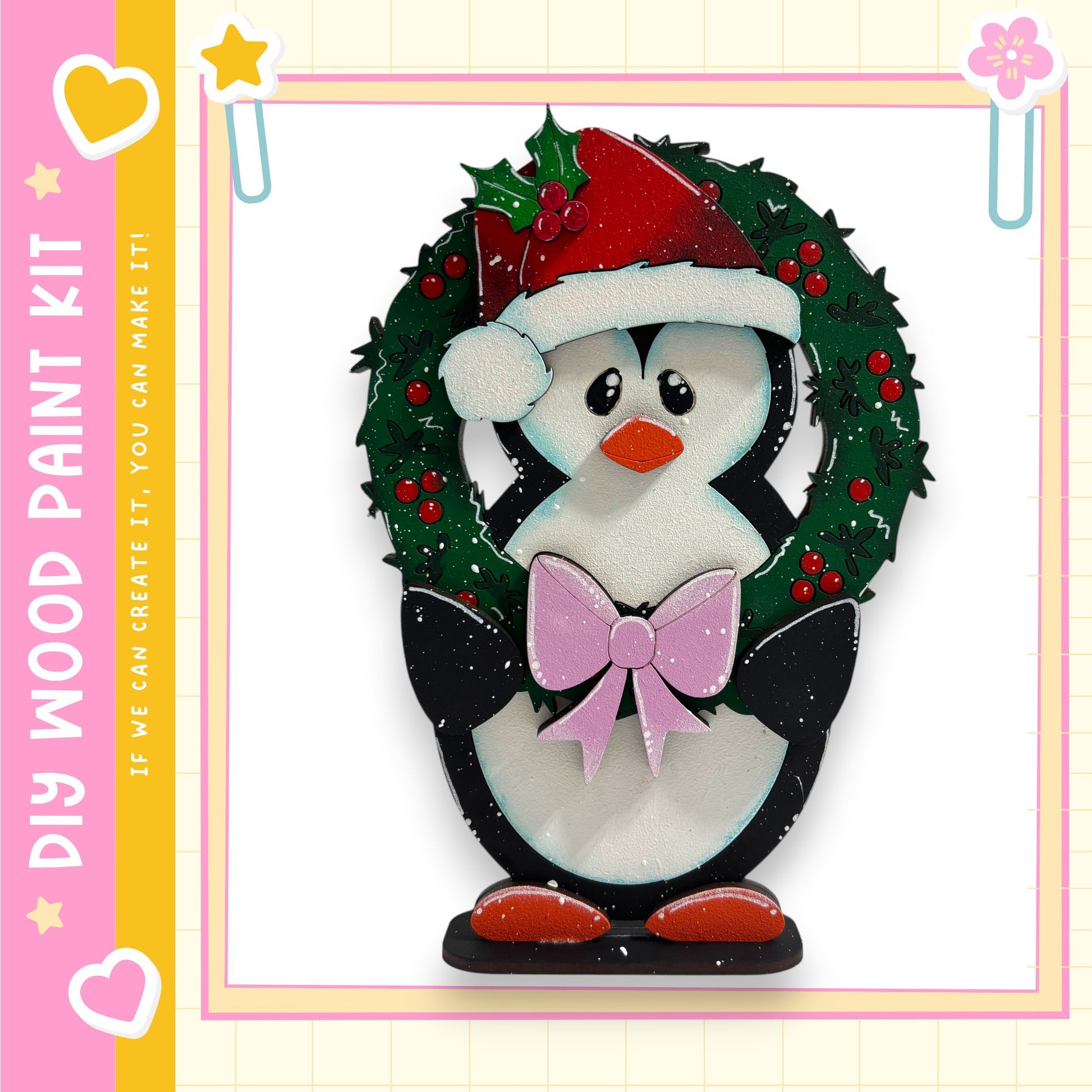 A wooden penguin wearing a Santa hat and holding a bow, standing in front of a wreath.