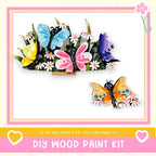 The image is a colorful and whimsical DIY wood paint kit featuring a variety of butterflies and flowers.