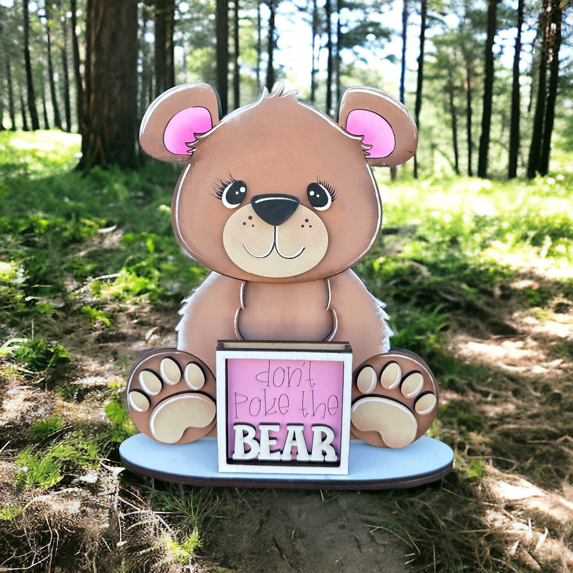 a brown teddy bear sitting on top of a sign