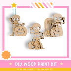 a DIY wood paint kit for creating Halloween-themed wooden figures, including skeletons and pumpkins.