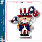 A wooden figure of a man wearing a hat with stars and stripes, holding a flag and balloons, representing the United States.
